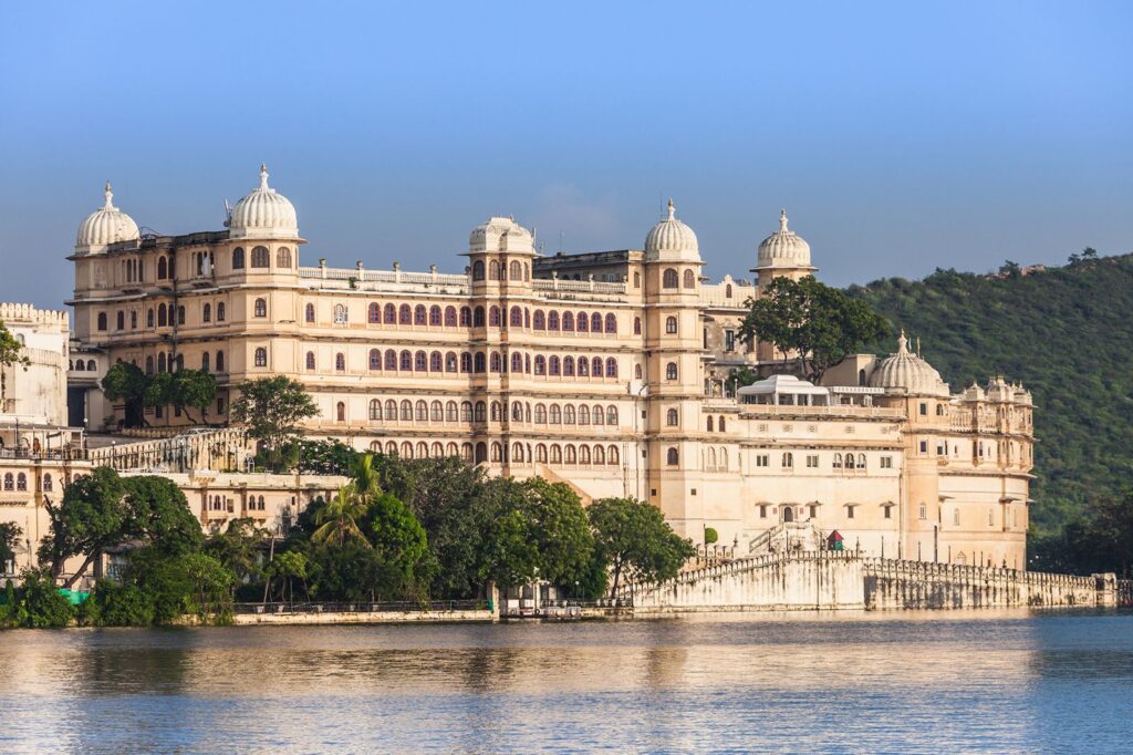 "Udaipur City Palace on the banks of Lake Pichola in Rajasthan, India, showcasing intricate Rajasthani architecture against a serene lakeside backdrop."