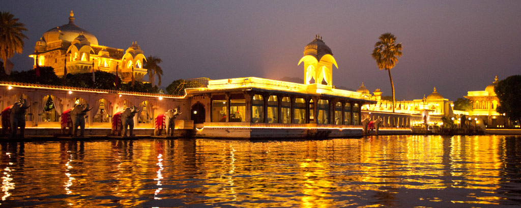 "Jag Mandir Palace illuminated at night, reflecting on the waters of Lake Pichola in Udaipur, Rajasthan."